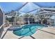Inviting swimming pool and spa within screened enclosure, enhanced by lush greenery at 1005 E 2Nd St, Englewood, FL 34223
