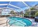 Sparkling pool with attached jacuzzi and screen enclosure, surrounded by lush landscaping at 1005 E 2Nd St, Englewood, FL 34223