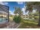Backyard featuring a screened-in pool and peaceful pond at 1216 Whitney Dr, Venice, FL 34293