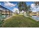Backyard pond view with a screened-in pool at 1216 Whitney Dr, Venice, FL 34293