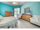 Bright bedroom featuring tile flooring, turquoise walls, and sliding glass door to outdoor living space at 1216 Whitney Dr, Venice, FL 34293