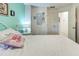 Bright bedroom featuring a cozy bed with floral bedding and light green accent wall at 1216 Whitney Dr, Venice, FL 34293