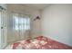 Empty bedroom showcasing a window with sheer curtains and a light-colored tile floor at 1216 Whitney Dr, Venice, FL 34293