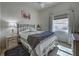 Cozy bedroom featuring a window and a bed with a floral patterned quilt and a dark blue throw at 1216 Whitney Dr, Venice, FL 34293