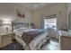 Cozy bedroom featuring a window and a bed with a floral patterned quilt and a dark blue throw at 1216 Whitney Dr, Venice, FL 34293