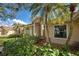 Beautiful home with a lush garden with palm trees and a large window at 1216 Whitney Dr, Venice, FL 34293