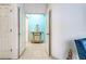 Hallway view towards sitting room highlighting a decorative cabinet and neutral tile floors at 1216 Whitney Dr, Venice, FL 34293
