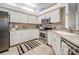 Well-lit kitchen with updated stainless steel appliances, stone countertops, and mosaic backsplash at 1216 Whitney Dr, Venice, FL 34293