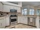 Kitchen featuring stainless steel appliances, tiled floors, and view to screened-in patio at 1216 Whitney Dr, Venice, FL 34293