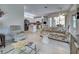 Open-concept living room with tile floors, a floral sofa, and views into the kitchen and dining area at 1216 Whitney Dr, Venice, FL 34293