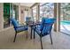 Cozy patio with a dining set and peaceful views of the pool and lake at 1216 Whitney Dr, Venice, FL 34293