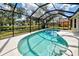 A stunning view of the screened-in pool with a lovely pond behind the home at 1216 Whitney Dr, Venice, FL 34293