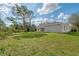 Spacious backyard with grassy area and mature trees at 1312 Wasilla St, North Port, FL 34291