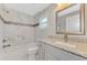 Modern bathroom with granite countertop, marble shower, and gray cabinets at 1312 Wasilla St, North Port, FL 34291