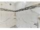 Walk-in shower with marble tile and pebble floor at 1312 Wasilla St, North Port, FL 34291