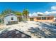 Spacious backyard with palm trees, a shed and an orange house exterior at 1340 Holiday Dr, Englewood, FL 34223