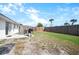 Outdoor patio with grill, seating in a fenced backyard, and green lawn at 1455 New Point Comfort Rd, Englewood, FL 34223