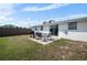 Outdoor patio with grill, seating in a fenced backyard, and green lawn at 1455 New Point Comfort Rd, Englewood, FL 34223