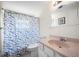 Bathroom featuring a pink vanity, nautical-themed shower curtain, and decorative mirror at 1455 New Point Comfort Rd, Englewood, FL 34223