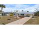 Charming single-story home with a neatly kept front yard, featuring a long driveway and ample parking space, with tropical landscaping at 1455 New Point Comfort Rd, Englewood, FL 34223