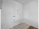 A white paneled front door with glass insert, set against a light tile floor and plain walls at 1455 New Point Comfort Rd, Englewood, FL 34223
