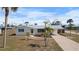 Charming single-story home featuring a metal roof, a covered carport, and a well-maintained front yard with mature palm trees at 1455 New Point Comfort Rd, Englewood, FL 34223