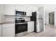 Modern kitchen with stainless steel appliances, tile floors, and bright white cabinets at 1455 New Point Comfort Rd, Englewood, FL 34223