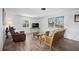 Bright living room with wood-look flooring, multiple windows, and comfortable furniture at 1455 New Point Comfort Rd, Englewood, FL 34223