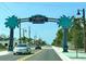 Inviting view of West Dearborn Street in Englewood, adorned with palm trees, featuring a gateway sign and smooth, fresh pavement at 1455 New Point Comfort Rd, Englewood, FL 34223