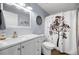 Clean bathroom with white vanity, mirror, and a shower with tree-themed curtain at 1493 New Point Comfort Rd, Englewood, FL 34223