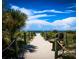 Sandy path with rope railings leads to a serene beach, offering a tranquil escape and scenic ocean views at 1493 New Point Comfort Rd, Englewood, FL 34223