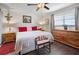 Cozy bedroom with a white bed, a wooden dresser, and lots of natural light from a window at 1493 New Point Comfort Rd, Englewood, FL 34223
