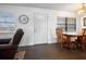 Bright dining area featuring a wood table, a large clock, and natural light from two windows at 1493 New Point Comfort Rd, Englewood, FL 34223