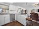 Bright kitchen features white cabinets, stainless steel appliances, granite countertops and wood floors at 1493 New Point Comfort Rd, Englewood, FL 34223