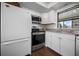 Bright kitchen features white cabinets and stainless steel appliances at 1493 New Point Comfort Rd, Englewood, FL 34223