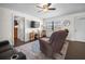 Inviting living room featuring a ceiling fan, a TV, and two chairs on a decorative rug at 1493 New Point Comfort Rd, Englewood, FL 34223