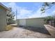 Side view of the large, light green shed with a white garage door at 1493 New Point Comfort Rd, Englewood, FL 34223