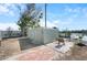 Rear yard showing brick paver patio with table and chairs next to large shed with multiple doors and view of the water at 1493 New Point Comfort Rd, Englewood, FL 34223