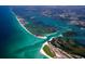 Expansive aerial shot of a coastline featuring clear turquoise waters, sandy beaches, and lush green islands at 1495 New Point Comfort Rd, Englewood, FL 34223