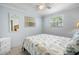 Serene bedroom with seashell bedding, tile flooring, and natural light from the windows at 1495 New Point Comfort Rd, Englewood, FL 34223