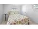 Bright bedroom with a white frame bed, seashell bedding, tile flooring, and a side table at 1495 New Point Comfort Rd, Englewood, FL 34223