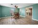 Open-concept dining room with wooden floors and a view into the kitchen and common area at 1495 New Point Comfort Rd, Englewood, FL 34223