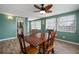 Dining room with wooden table and chairs, ceiling fan, and natural light from large windows at 1495 New Point Comfort Rd, Englewood, FL 34223