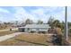 Inviting single-story home showcasing light exteriors, carport, tidy landscaping, and generous front yard space at 1495 New Point Comfort Rd, Englewood, FL 34223