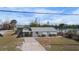 Well-maintained single-story home featuring a convenient carport, light exterior paint, and landscaped front yard at 1495 New Point Comfort Rd, Englewood, FL 34223