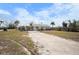 Charming single-story home boasting a light exterior paint and spacious front yard with tidy landscaping at 1495 New Point Comfort Rd, Englewood, FL 34223