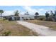 Well-maintained single-story home featuring a convenient carport, light exterior paint, and manicured front yard at 1495 New Point Comfort Rd, Englewood, FL 34223