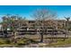 Two-story building with balconies, mature trees, and parking at 1501 Beach Rd # 209, Englewood, FL 34223