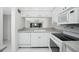 Bright kitchen features white cabinets, granite countertops, and modern appliances at 1501 Beach Rd # 209, Englewood, FL 34223