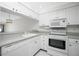 White kitchen with granite countertops and stainless steel appliances at 1501 Beach Rd # 209, Englewood, FL 34223